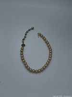 Full view of graduated faux pearl necklace in oval layout
