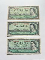 Fronts of three 1954 $1 Canadian bills showing portrait, denomination and serial numbers