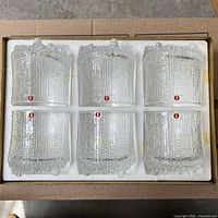 Six clear textured glass tumblers in foam packaging
