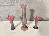 Front view of three marbled glass vases