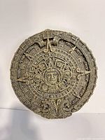 Front of circular Aztec Sun Stone plaque showing detailed relief design