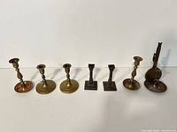 All seven candlestick holders lined up showing size and styles