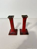 Front view of both red Obay Art Ware candlesticks