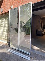 two mirrored closet doors leaning against wall