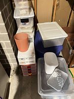 Group of assorted plastic storage items stacked together