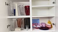 Overview of two-door cabinet showing vases on left and bowls/dishes on right