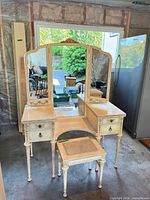 Full view of vanity, tri-fold mirror, and stool