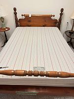 Full view of assembled bed frame with mattress showing headboard, footboard and side tables