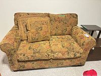 Full view of floral tapestry loveseat with two throw pillows
