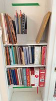 Shelf view showing various cookbooks and binders