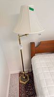 Full view of brass floor lamp with shade