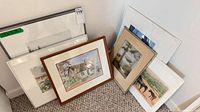 Group view of six artworks leaning against wall