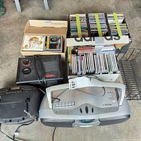 Lot overview showing both boomboxes, Reactor unit, boxes of CDs, wire rack