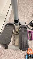 Full view mini stepper pedals and nearby dumbbells