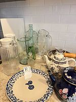Group shot showing pitchers, teapots, plate and decanter