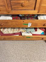 Drawer showing mixed folded linens: plaid, floral, solid, ivory