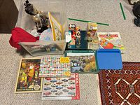 Overall lot showing bin with contents, puzzles laid out, games visible