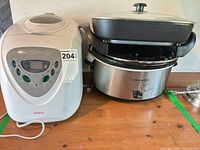 Bread maker and slow cooker with griddle shown side by side