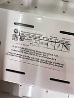 Fixture data label showing brand, voltage, wattage, mounting info