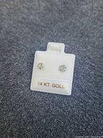both earrings on display card marked 14 KT. GOLD