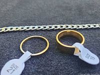 Close-up of rings size tags and curb chain links
