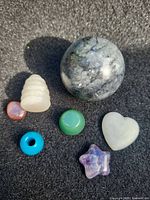 All seven gemstone pieces including sphere, carvings, beads