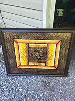 full view of framed abstract painting leaning against siding