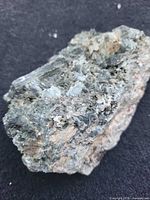 Oblique view of green actinolite crystals on tan rock matrix
