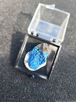Azurite malachite specimen in display box showing blue, green, brown coloration