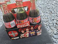 Front view of 6-pack showing bottles, caps, and carrier graphics