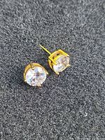 front view showing clear round stones in gold tone prong settings