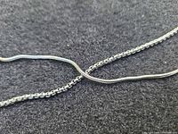 Close-up of snake and rolo chains showing link styles and silver finish