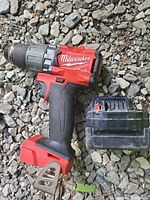 Milwaukee M18 Fuel drill/driver front view beside battery