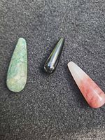 Front view of three teardrop cabochon gemstones on black background