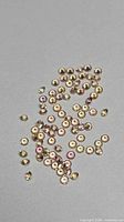 Loose round champagne and pink sapphires scattered on grey background