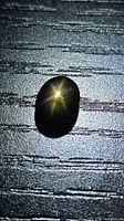 Front view of oval cabochon star sapphire showing golden six-ray star