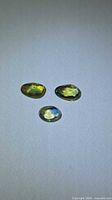 Front view of three tricolored rose cut sapphires on neutral background