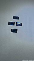Four rectangular blue sapphires on neutral background