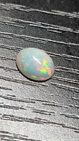 Top view of oval opal showing multicolored play of color