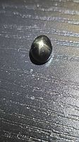 Black star diopside oval cabochon front view showing star asterism