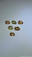 Six oval sapphires in varying yellow-green hues