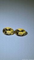 Pair of oval golden citrines side by side on neutral background