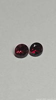 Pair of round garnets side by side showing cherry red hue
