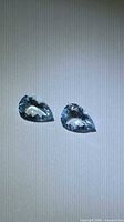 Two pear-cut aquamarines on background