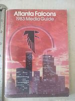 Front cover of 1983 Atlanta Falcons media guide with skyline graphic