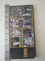 Front cover showing action photos and ruler indicating size