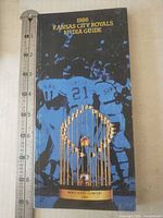 Front cover with title, trophy graphic and ruler for scale