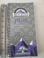 Front cover showing Colorado Rockies 1998 Information Guide design and ruler for scale