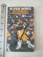 Front cover of paperback with tape measure for size reference