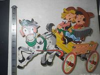 Full view of die-cut wall decor showing horse, wagon, children with ruler for scale